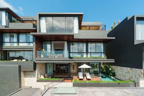 A modern multi-story house with a balcony, outdoor seating, and a swimming pool. - Villa Solaia by Alfred in Bali (Pecatu)