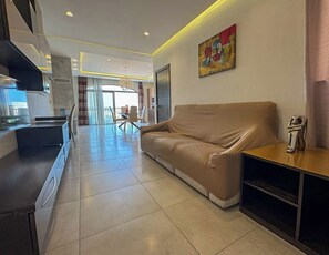 Ein modernes Wohnzimmer mit einer Couch, einem Couchtisch und einer TV-Konsole.