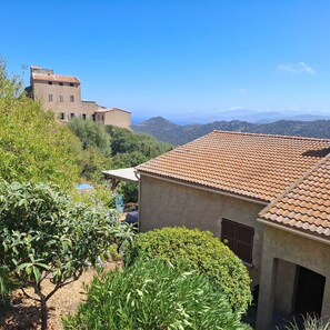 A building with a tiled roof, surrounded by greenery and hills in the background. - Looking for peace and tranquility in the heart of Balagne, Corsica? (Monticello)