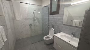 A modern bathroom with a glass-enclosed shower, a toilet, and a sink. - Hawana Lagoons (ولاية طاقة،)