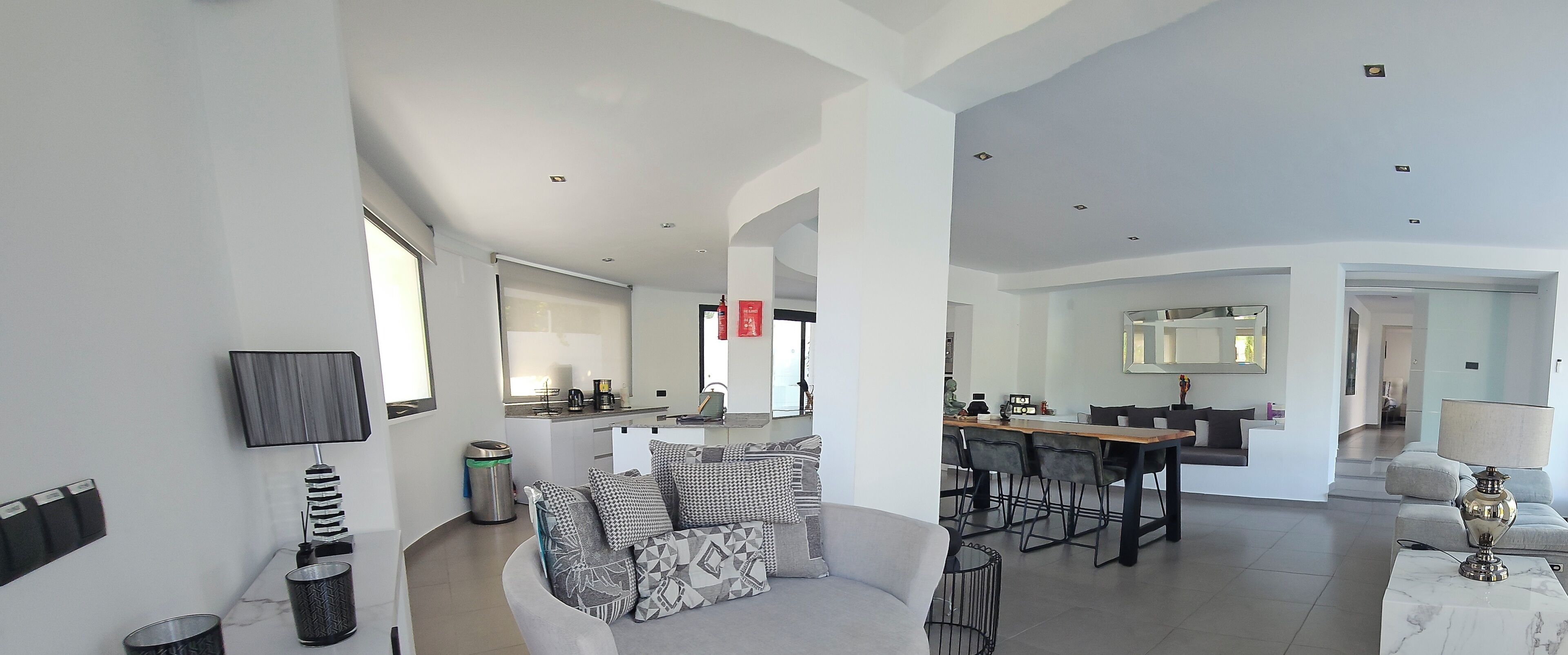 A spacious living area with a sofa, coffee table, and a dining table with chairs.