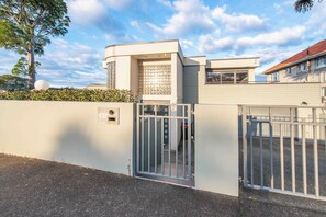 Il s'agit d'une propriété privée, fermée par un portail, dotée d'une architecture moderne, notamment d'une façade incurvée et d'un garage.