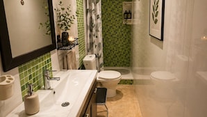 A modern bathroom with a dual sink vanity, a shower enclosure, and a toilet.