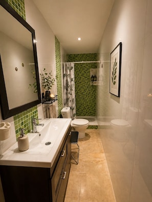 Un bagno moderno con un mobile lavabo doppio, uno spazio doccia e un WC.