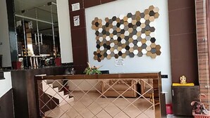 A reception desk with a geometric pattern on the wall behind it. - Ramoji Resorts (Hathras)