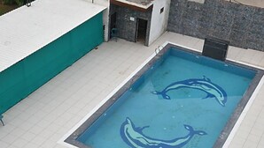 A rectangular swimming pool with dolphin designs on the water's surface. - Ramoji Resorts (Hathras)