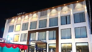 A multi-story hotel with a central entrance, large windows, and a covered outdoor area. - Ramoji Resorts (Hathras)