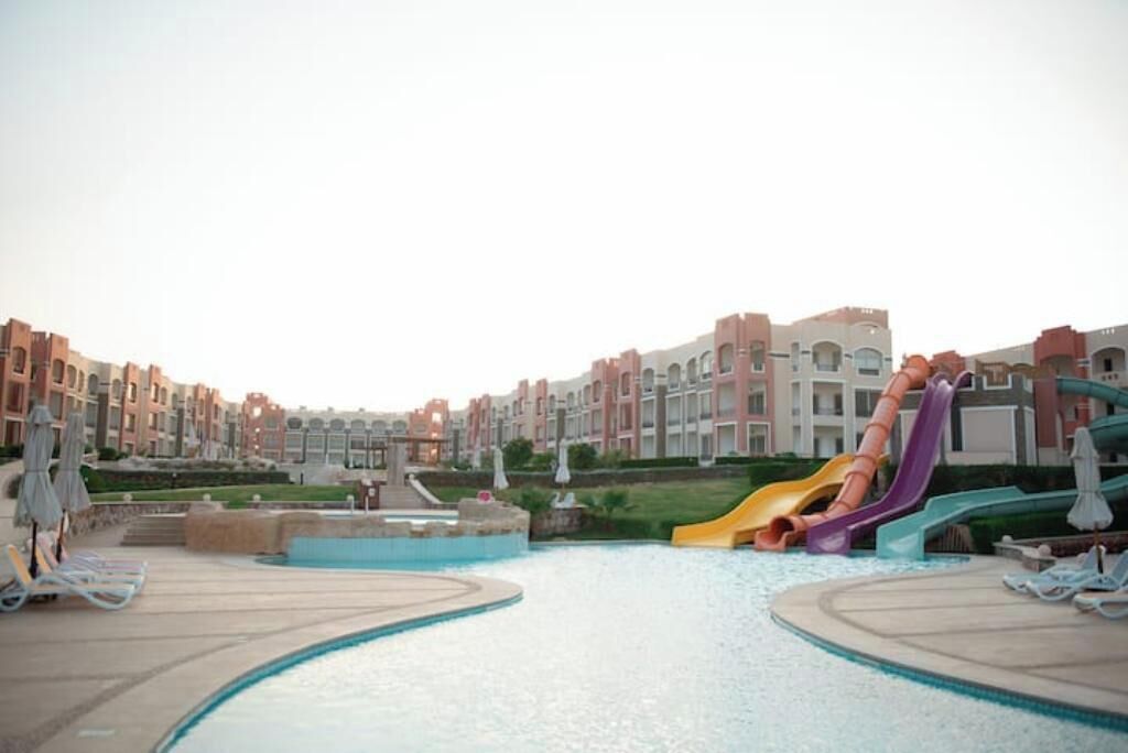Una piscina con múltiples toboganes rodeada de edificios.