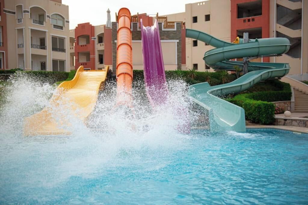 Um parque aquático com vários toboáguas e uma piscina.