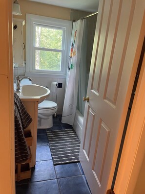 Une petite salle de bain comprenant des toilettes, un lavabo et un rideau de douche.