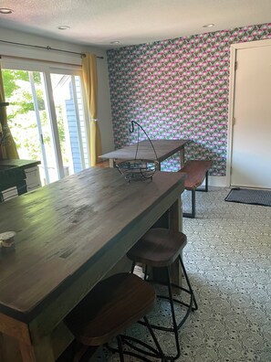 Un coin repas avec une table en bois, deux chaises et un panier en métal.
