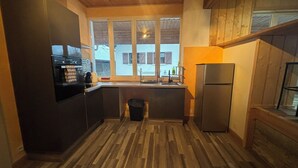 A compact kitchen with a built-in oven, a sink, and a refrigerator.