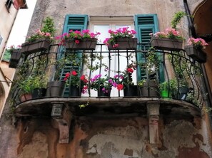 A balcony with flower boxes and potted plants. - Grande Giove – Spacious Family & Bike Home in the Heart of Finalborgo (Finale Ligure)