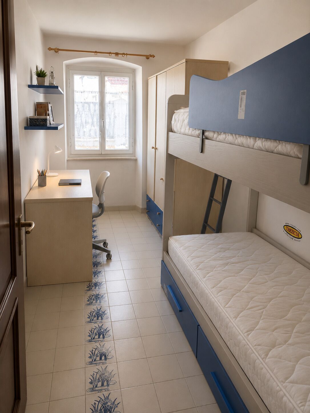 Un dormitorio con literas, un escritorio y una silla.