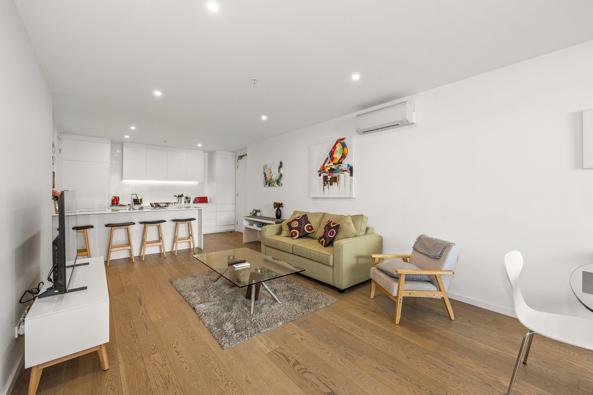 Een modern appartement met keuken, eethoek en woonkamer.