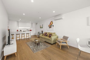 Um apartamento moderno com cozinha, sala de jantar e sala de estar.