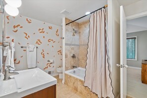 A bathroom with a bathtub, shower, and a sink. - Waterfront Annapolis Home Near USNA Stadium (Annapolis)