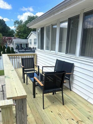 A wooden deck with outdoor furniture, a covered area, and a house in the background. - 4-Bedroom Arnold Retreat | Spacious Yard & Deck (Arnold)