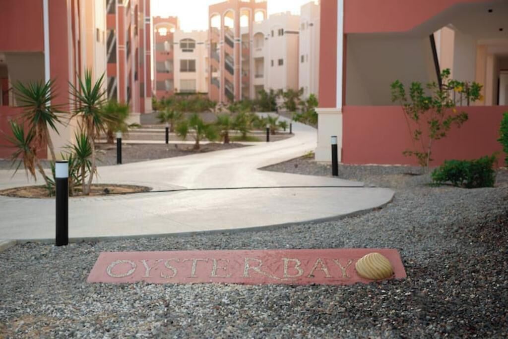 A pathway leading to a building with a sign that reads 'OYSTER BAY.'