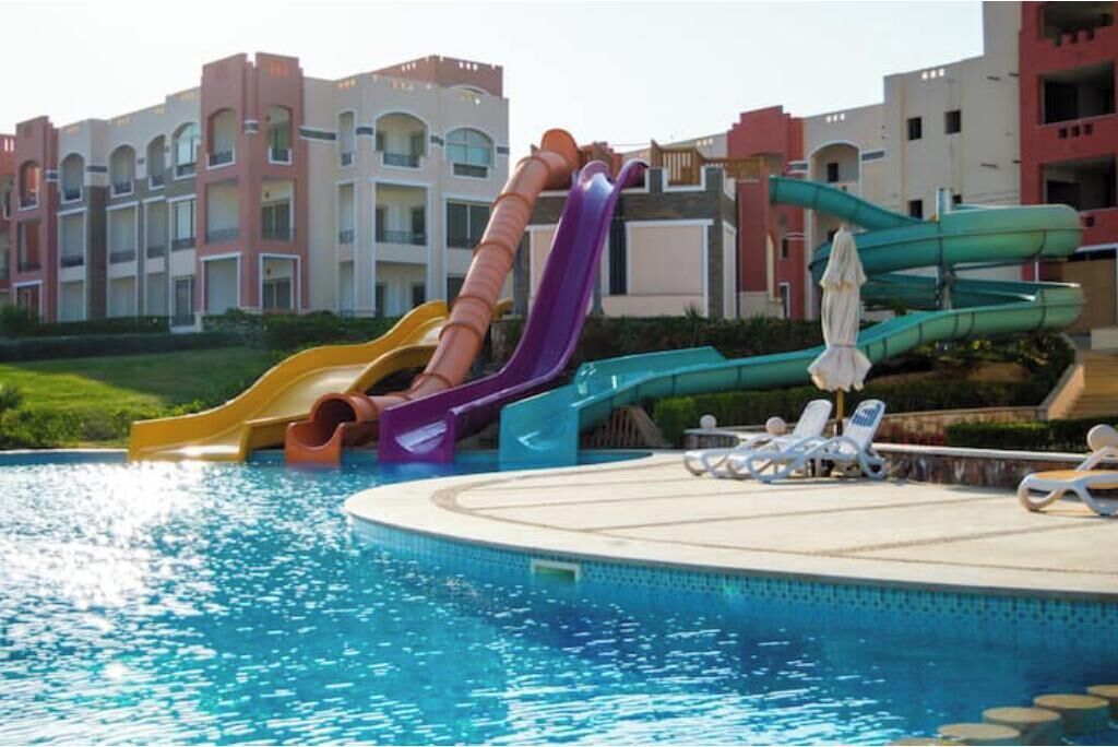 Piscina com vários toboáguas e espreguiçadeiras.