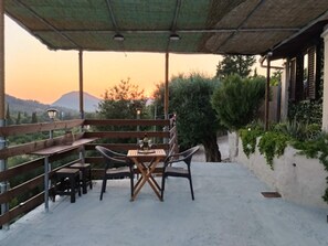 An outdoor patio with a table and chairs, a pergola, and a view of a mountain. - Aloni House Kokkini Corfu (Kokkini, Corfu)