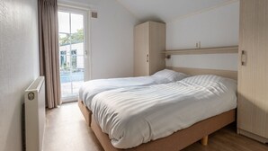 Quarto com uma cama de casal, guarda-roupa e radiador.