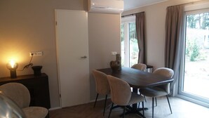 Uma sala de jantar com mesa, cadeiras e ar condicionado.