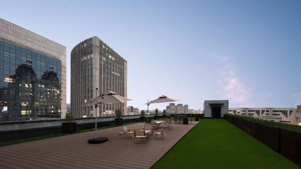 Una terraza en la azotea con asientos al aire libre y vistas de edificios circundantes.