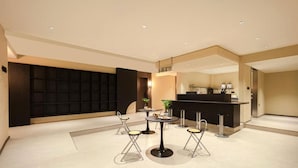 Un vestíbulo de hotel moderno con una recepción, zona de estar y un mueble de pared negro grande.