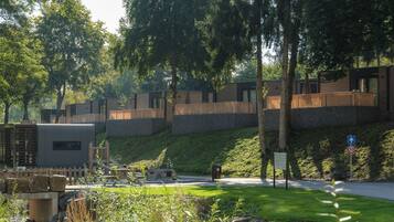 Un quartiere residenziale con case moderne, una strada asfaltata e un'area verde alberata.