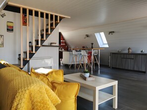 Un espai de vida modern d'estil loft, amb escala, zona de menjador i cuina.