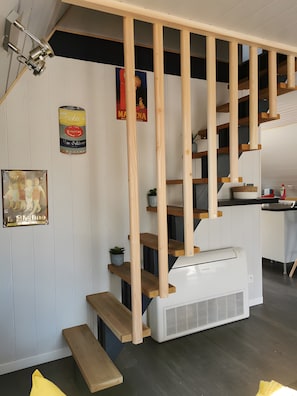 A staircase with wooden steps and a white air conditioning unit at the bottom.