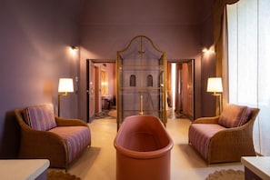 A room with two wicker chairs, a central tub, and a mirrored wall. - Palazzo Ceraselli (Martina Franca)