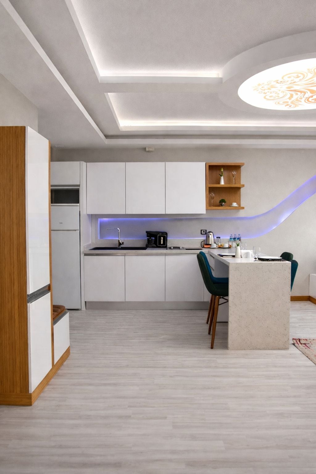 A modern kitchen with white cabinetry, a central island, and a built-in oven.