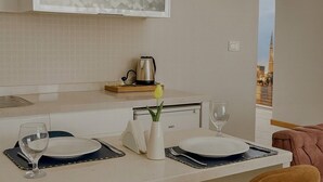 A modern kitchen with a central island, bar stools, and a view of a cityscape.