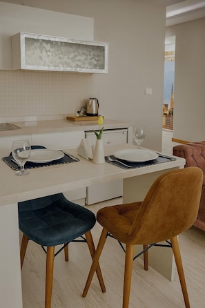 Una cocina moderna con una isla central, taburetes de bar y vistas a un paisaje urbano.
