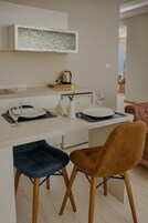 A modern kitchen with a central island, bar stools, and a view of a cityscape.