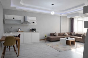 Una sala moderna con un sofá, una mesa de centro y una zona de comedor con una mesa y sillas.