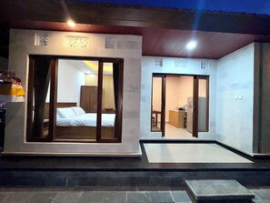 A hotel room with a bed, a desk, and a kitchenette.