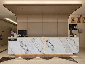 A reception desk with a marble top, a digital display, and a sign indicating 'RECEPTION'.