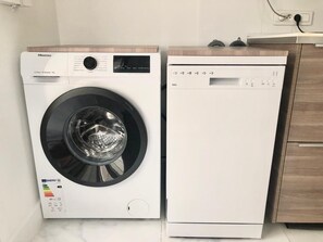 A Hisense washing machine and a dishwasher side by side in a kitchen. - Parisian Apart Center—Rue St.Charles,Near Beaugrenelle/ Eiffel Tower—75015 PARIS (Paris15)