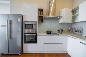 A modern kitchen with a stainless steel refrigerator, built-in oven, microwave, and a pot on the countertop. - Luxury 2BR Apartment -Nairobi National Park Views  at The Curve by the Park. (Nairobi)