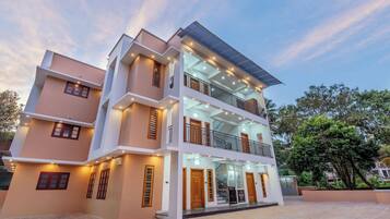 A multi-story building with a flat roof, balconies, and a reception area.