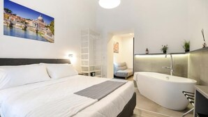 A modern bedroom with a large bed, a walk-in closet, a bathroom with a freestanding bathtub, and a cityscape painting on the wall.