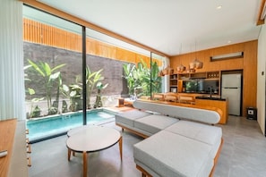 A modern living room with a pool, a sofa, and a dining area. - Solaris Ubud Villa by Tasvan (Gianyar)
