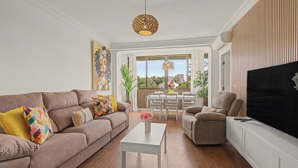 A living room with a sofa, armchair, TV, and a dining area with a table and chairs. - Apartamento 'Brisa del Sur' para 6 personas, Huelva y Portugal, Wifi, A/C, luminoso (Ayamonte)