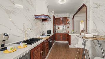 A modern kitchen with marble walls, a wooden cabinet, and a built-in oven.