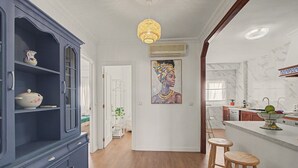 Una cocina moderna con protector mural de mármol, taburetes de madera y un cuadro en la pared.