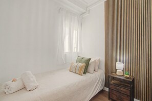 A bedroom with a single bed, a nightstand, a lamp, and a window with sheer curtains. - Apartment 'Brisa del Sur' (Isla Canela) for 6 guests, Huelva & Portugal, Wi-Fi, A/C and bright (Ayamonte)