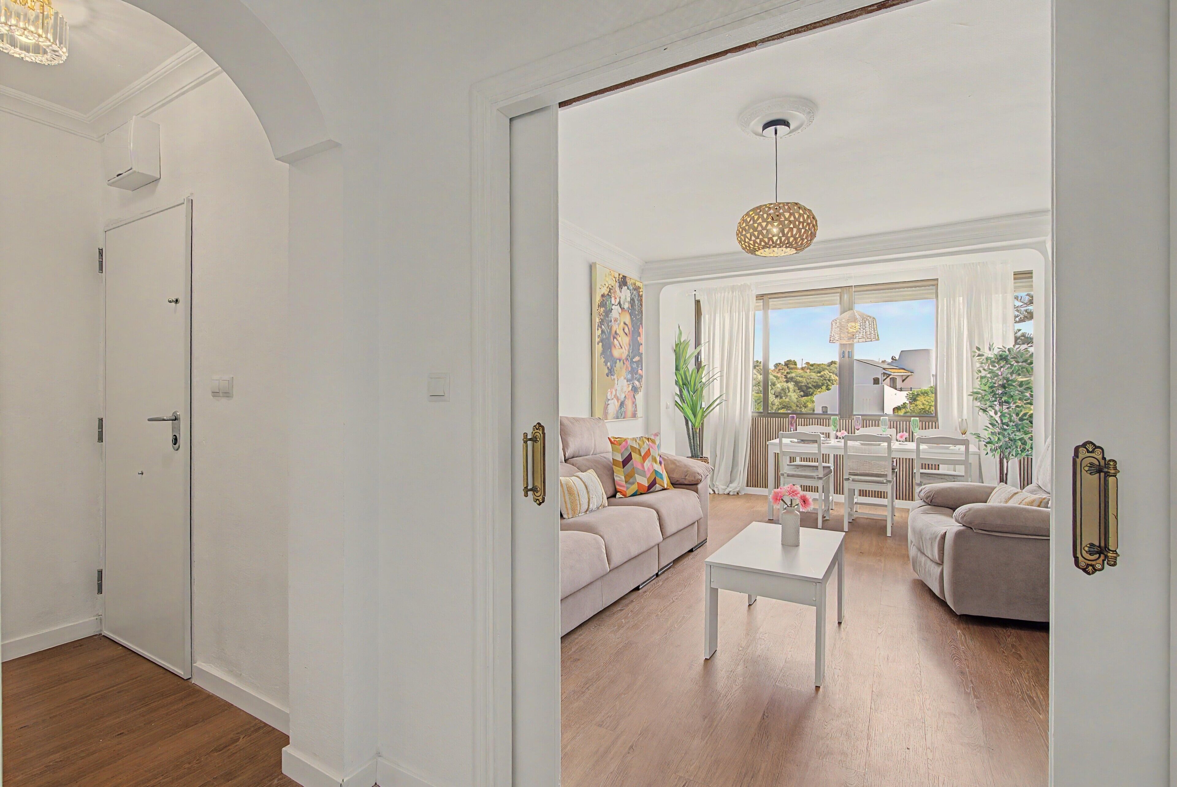 A spacious living room with a sofa, coffee table, and dining area.